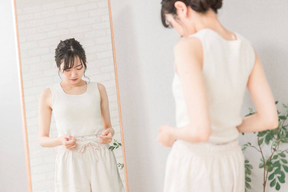 ウエストを測る女性