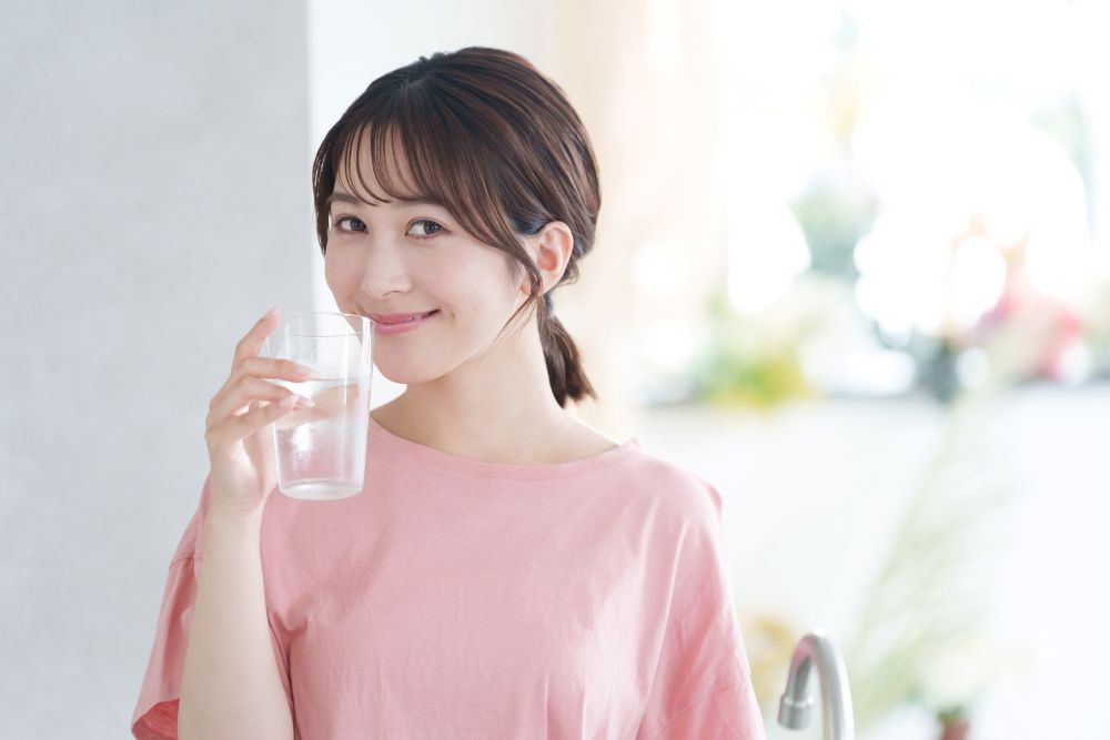 水を飲んで微笑む女性