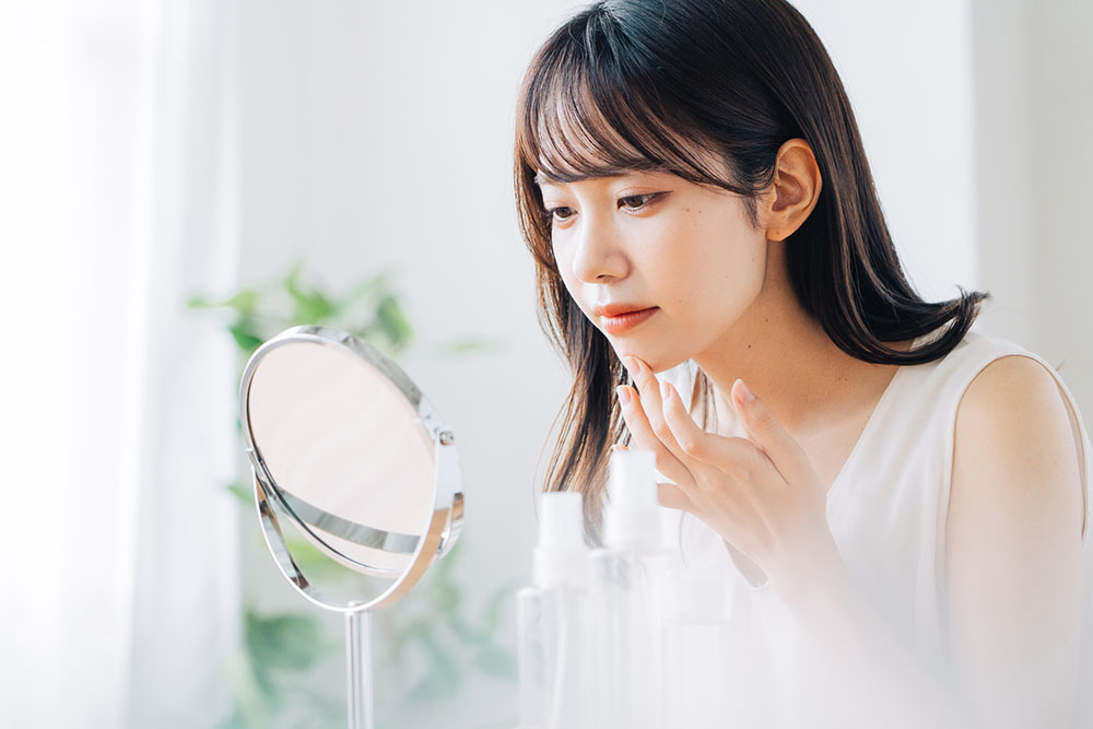 女性が顎に手をあてて肌を気にする様子